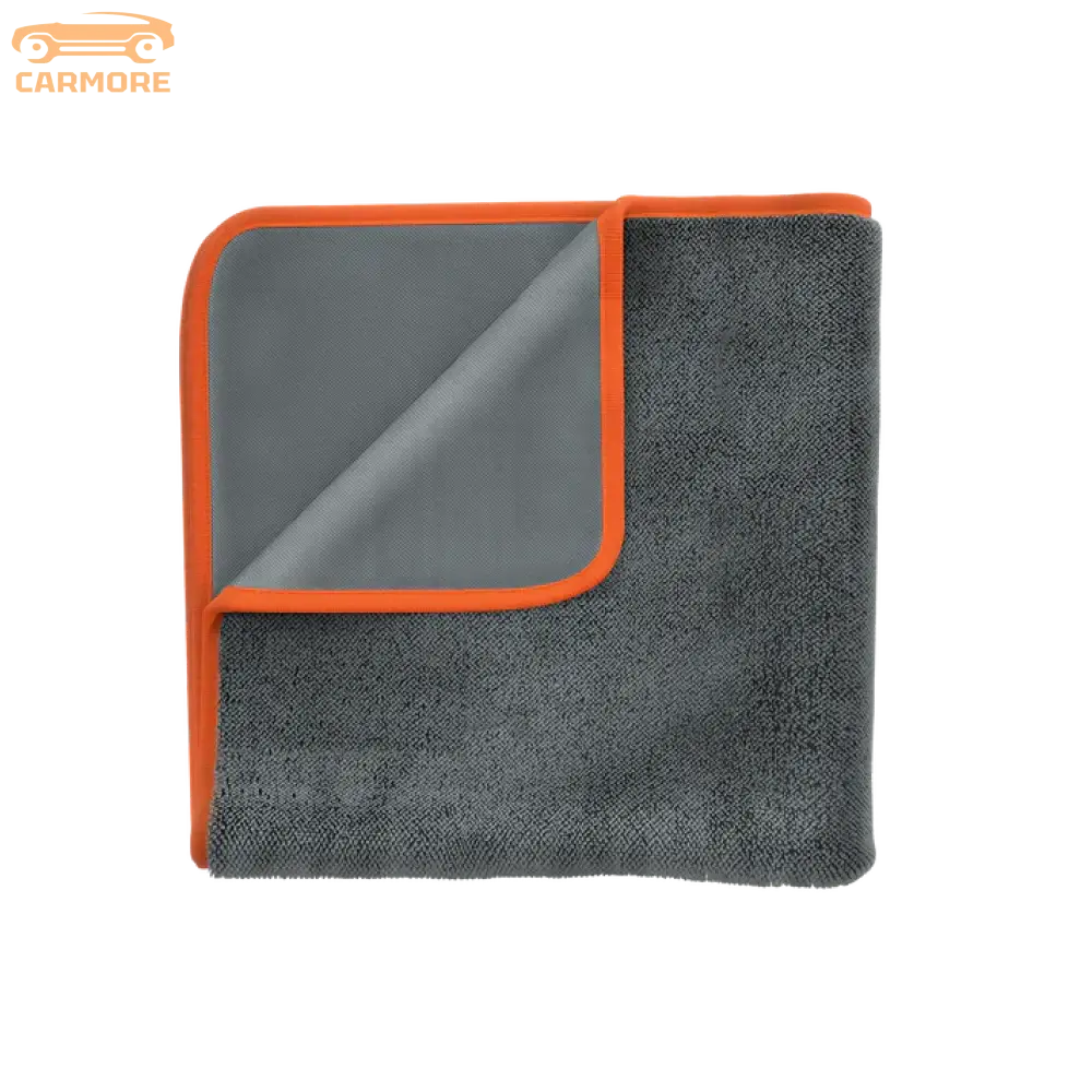 Folded dark gray microfiber car drying towel with orange trim on white background